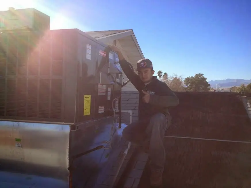 HVAC technician performing Heat Pump Repair on a rooftop unit in Garrison